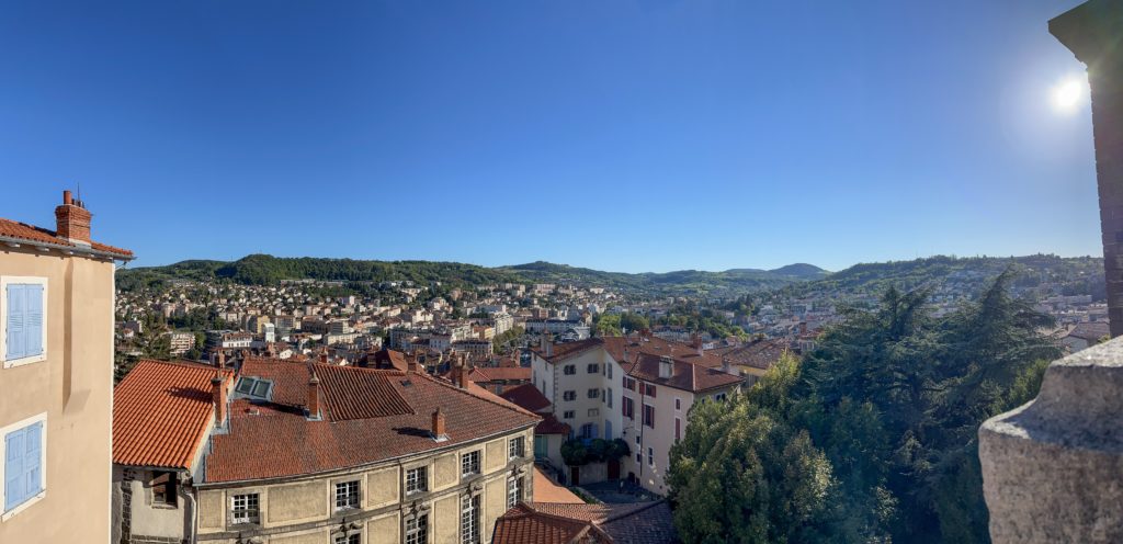 Panoramic view of Le Puy, with green volcanic hills in the background.