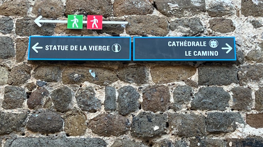 A sign in the Cathédrale Notre-Dame du Puy. To the right, Cathédral and Le Camino.